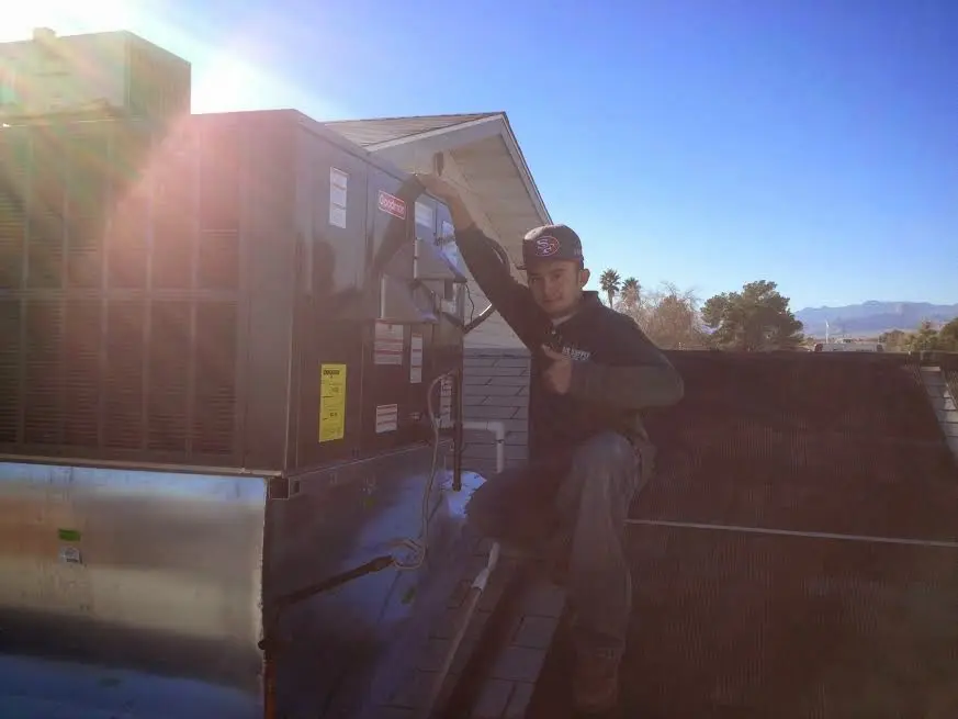 HVAC technician performing Air Duct Repair on a rooftop unit in Charles Town